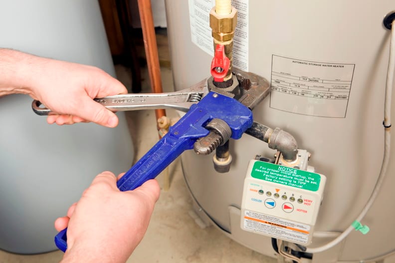 Plumber repairing a water heater valve in Bethel Park